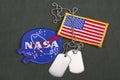 15 March 2018 - The National Aeronautics and Space Administration (NASA) emblem patch, dog tags, and US Flag patch on green Royalty Free Stock Photo