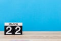 March 22nd. Day 22 of month, calendar on table with blue background. Spring time, empty space for text Royalty Free Stock Photo