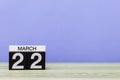 March 22nd. Day 22 of month, calendar on table with purple background. Spring time, empty space for text Royalty Free Stock Photo