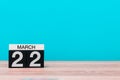 March 22nd. Day 22 of month, calendar on table with turquoise background. Spring time, empty space for text Royalty Free Stock Photo