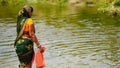 image of a woman stands towards edge of river