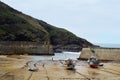 A view of the beach at low tide with boats on the beach in Port Isaac, Cornwall, England.