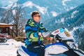 Young man riding a snowmobile on a track in the middle of the Austrian Alps.