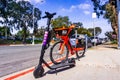 March 19, 2019 San Diego / CA / USA - Jump Electric Bike owned by Uber and Lyft Escooter parked side by side on the sidewalk,