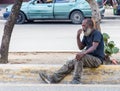 March15, 2020, Santo Doming, dominican republic. dramatic image of a man sitting on the divider of a busy downtown street begging.