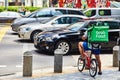 19 march, 2019 - Singapore: Courier for delivery of food `Grab` on a bicycle in Singapore Royalty Free Stock Photo