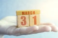 march 31st. Day 31of month,Handmade wood cube with date month and day on female palm spring month, day of the year concept