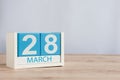 March 28th. Day 28 of month, wooden color calendar on table background. Spring time, empty space for text