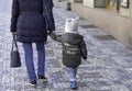 March 30th. 2019 Prague Center The Czech Republic Europe Mother and toddler holding hands walking on a cobble stone street