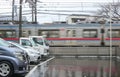 2020 March 02. Tokyo Japan. Japanese cars row with blurred running Keisei line train on raining day Royalty Free Stock Photo