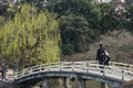 2017 MARCH 18. TOKYO JAPAN. A Japanese couple walking along the bridge among natural tree at SHINJUKU GYOEN national garden