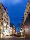 The famous street Graben at night with the lights of shops and crowds of tourists walking around