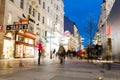 famous street Graben at night with the lights of shops and crowds of tourists walking around
