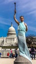 MARCH 24, 2018 - Washington DC, Female poses like Statue of Liberty in front of US Capitol,. Statue, background Royalty Free Stock Photo