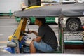 Young man waits for passengers in Tuk Tuk, Bangkok, Thailand Royalty Free Stock Photo