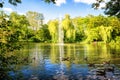 Pond, lake in the park, nature reserve, recreational area with fountain in the middle and with beautiful green trees in the backgr Royalty Free Stock Photo