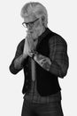 Close-up black and white portrait of a handsome tattooed silver fox with hipster glasses praying on an isolated white background Royalty Free Stock Photo