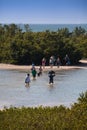 Unidentifiable people wade across the lagoon to get to Tigertail Beach on Marco Island