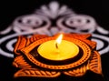 Marco shot of one beautiful shining terracotta lamp and white rangoli on black background. diwali concept Royalty Free Stock Photo