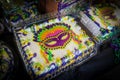 Mardi gra cakes decorated with masks for sale with plastic covers