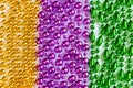 Mardi Gras background. Multi-colored beads close-up. Festive decorations in gold, green and purple colors. Fat Tuesday Royalty Free Stock Photo