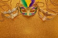 Mardi gras or carnival mask with beads on gold glowing background. Venetian mask. Royalty Free Stock Photo