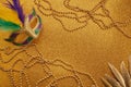Mardi gras or carnival mask with beads on gold glowing background. Venetian mask. Royalty Free Stock Photo