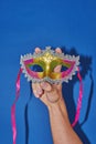 Mardi Gras masquerade mask on blue with confetti, copy space Royalty Free Stock Photo