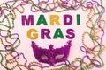 Mardi Gras party concept. Flat lay lettering Mardi Gras, colorful beads and carnival mask