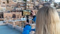 Tourist taking a photo of old town Mardin cityscape at a rooftop, Mardin, Turkey