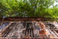 Rectangular windows on an old ruined dilapidated Portuguese era mansion overgrown with trees