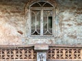 An arch window on the grungy wall of an old house in Goa