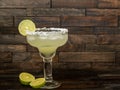 Margarita drink in a glass with sliced lime and a salted rim on a rustic wood background Royalty Free Stock Photo