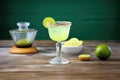 margarita glass with lime and salted rim, tequila bottle behind Royalty Free Stock Photo