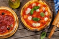 Margarita and pepperoni pizza with tomatoes, mozzarella cheese and basil Royalty Free Stock Photo