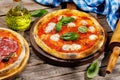 Margarita and pepperoni pizza with tomatoes, mozzarella cheese and basil Royalty Free Stock Photo