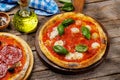 Margarita and pepperoni pizza with tomatoes, mozzarella cheese and basil Royalty Free Stock Photo