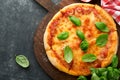 Margarita pizza. Traditional neapolitan margarita pizza and cooking ingredients tomatoes basil on old concrete texture background Royalty Free Stock Photo