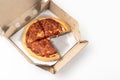 Margherita Pizza in a cardboard open delivery box on a white background. A piece is missing from the box. Top view Royalty Free Stock Photo