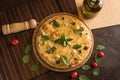 Marguerita pizza with top view, decorated with basil, cherry tomatoes and black olives