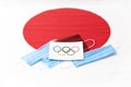 Mari El, Russia - June 16, 2021: Olympic flag is on the document and blue masks. The Japanese flag background. Tourist trip