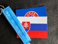 Mari El, Russia - June 12, 2021: UEFA logo and Slovakia, Slovak flag is near a blue mask on the dark gray background. Tourist trip