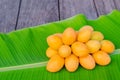 Marian plum or Ma Yong Chid on banana leaf background