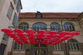 Stunning landscape view of roof of red umbrellas in front of the main entrance to the Regional Museum of Maribor