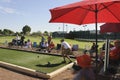 Senior Man rolls ball to play the sport of bocce ball.