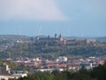 Marienburg fortress above WÃ¼rzburg photographed from a distance with wind turbines