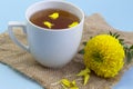 Marigold herbal tea in a glass cup fresh flowers on sackcloth Royalty Free Stock Photo