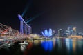 Marina Bay Sands with colorful light show and helix bridge.