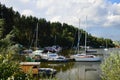 Marina with boats, yachts and houseboats on Orava River Dam, northern Slovakia, during cloudy summer day.