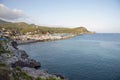 Bay and harbor with breakwater and cliff at sunset.